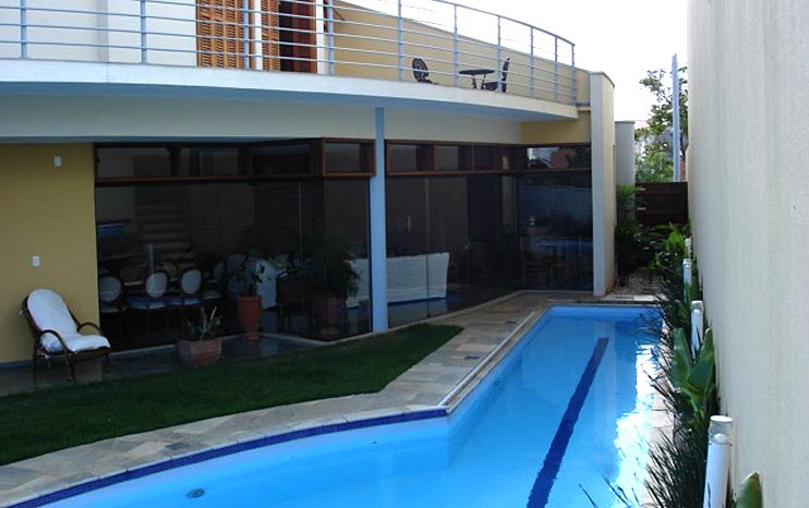Residência com piscina e grandes panos de vidro